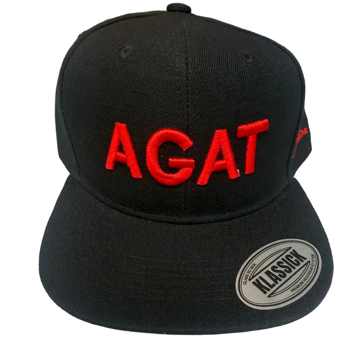 A black flat-brim snapback cap with 'AGAT' embroidered in red across the front panels. A silver oval sticker reading 'CLASSIC' is visible on the brim, and a small red logo is embroidered on the side.