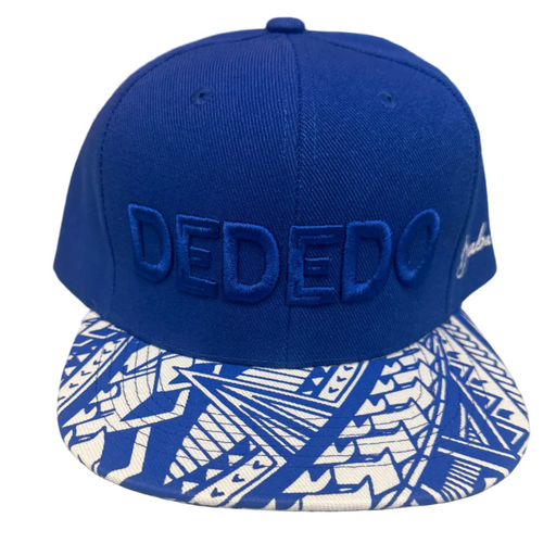 A royal blue snapback cap with 'DEDEDO' embroidered on the front and a blue and white geometric patterned visor, displayed on a light gray surface.