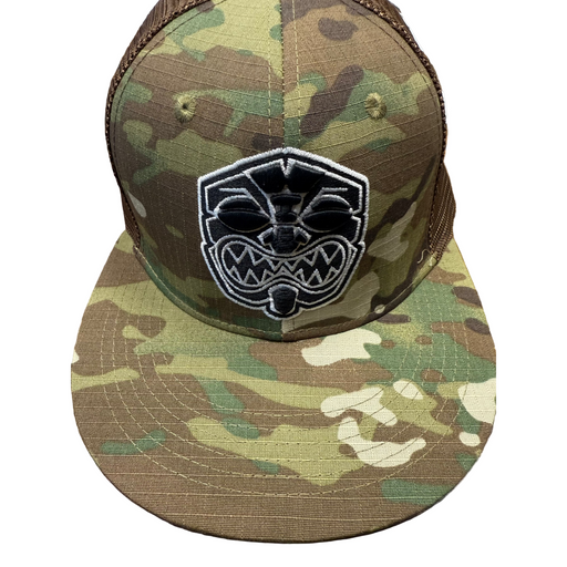 Camouflage baseball cap with a black and white logo on a wooden surface