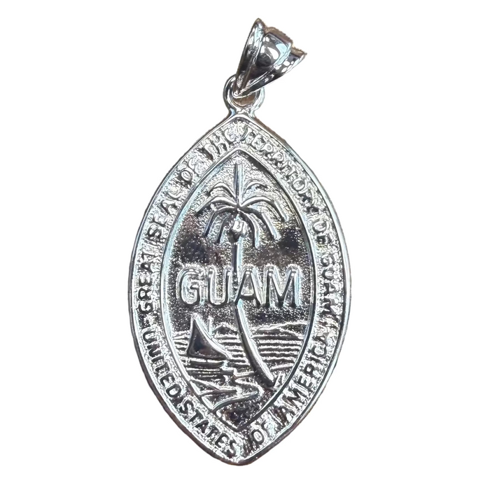 Silver Guam pendant on a wooden surface