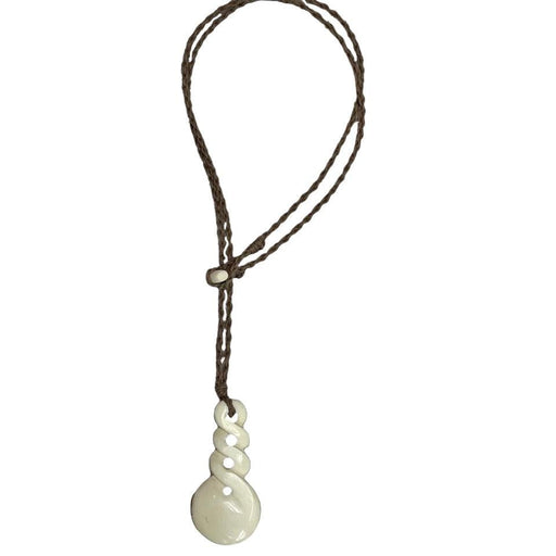 White pendant on a brown cord against a black background