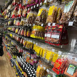 Supermarket aisle with various packaged goods and drinks on shelves.