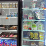 Frosted glass door of a refrigerator stocked with various drinks and products.