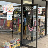 Storefront with glass doors and colorful displays inside, featuring a sign with the number 5505.